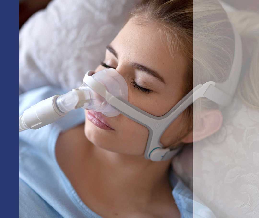 Ein Frau mit Schlafapnoe trägt eine CPAP-Maske zur Unterstützung ihrer Atmung beim Schlafen.