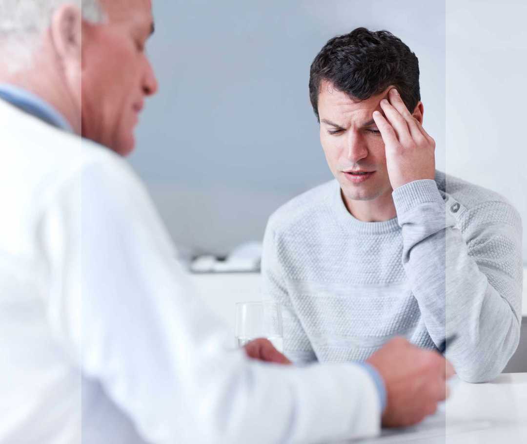 Mann mit schmerzenden Stirnhöhlen im Gespräch mit einem Arzt