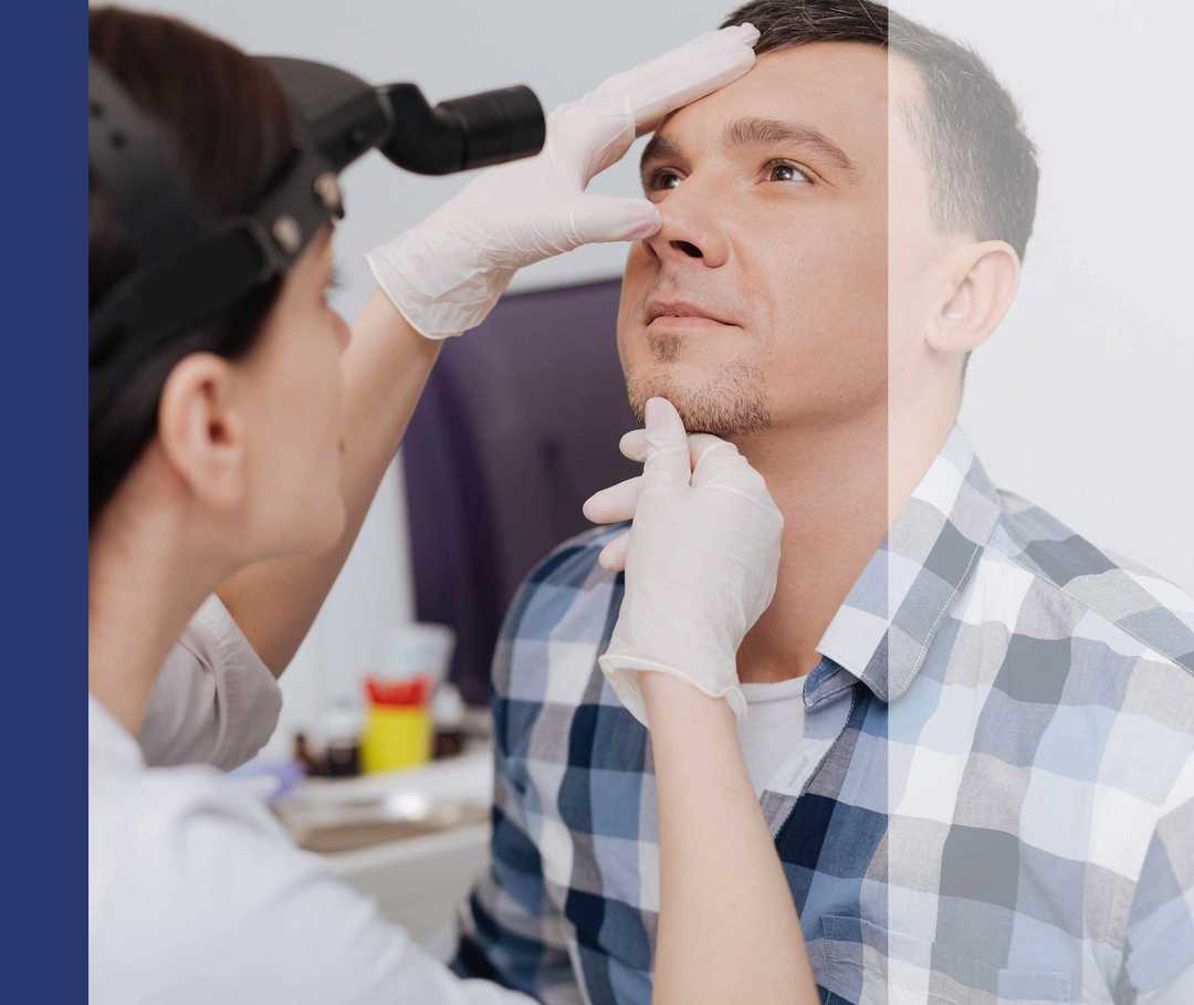 HNO-Ärztin untersucht die Nasenhöhlen eines Mannes.