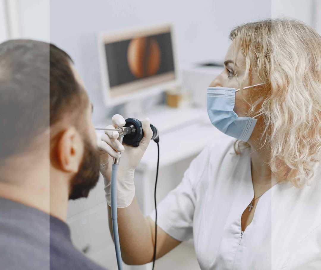Nasenpolypen Diagnose Artikelbild 02 HNO-Ärztin führt eine endoskopische Untersuchung der Nase bei einem Mann durch.