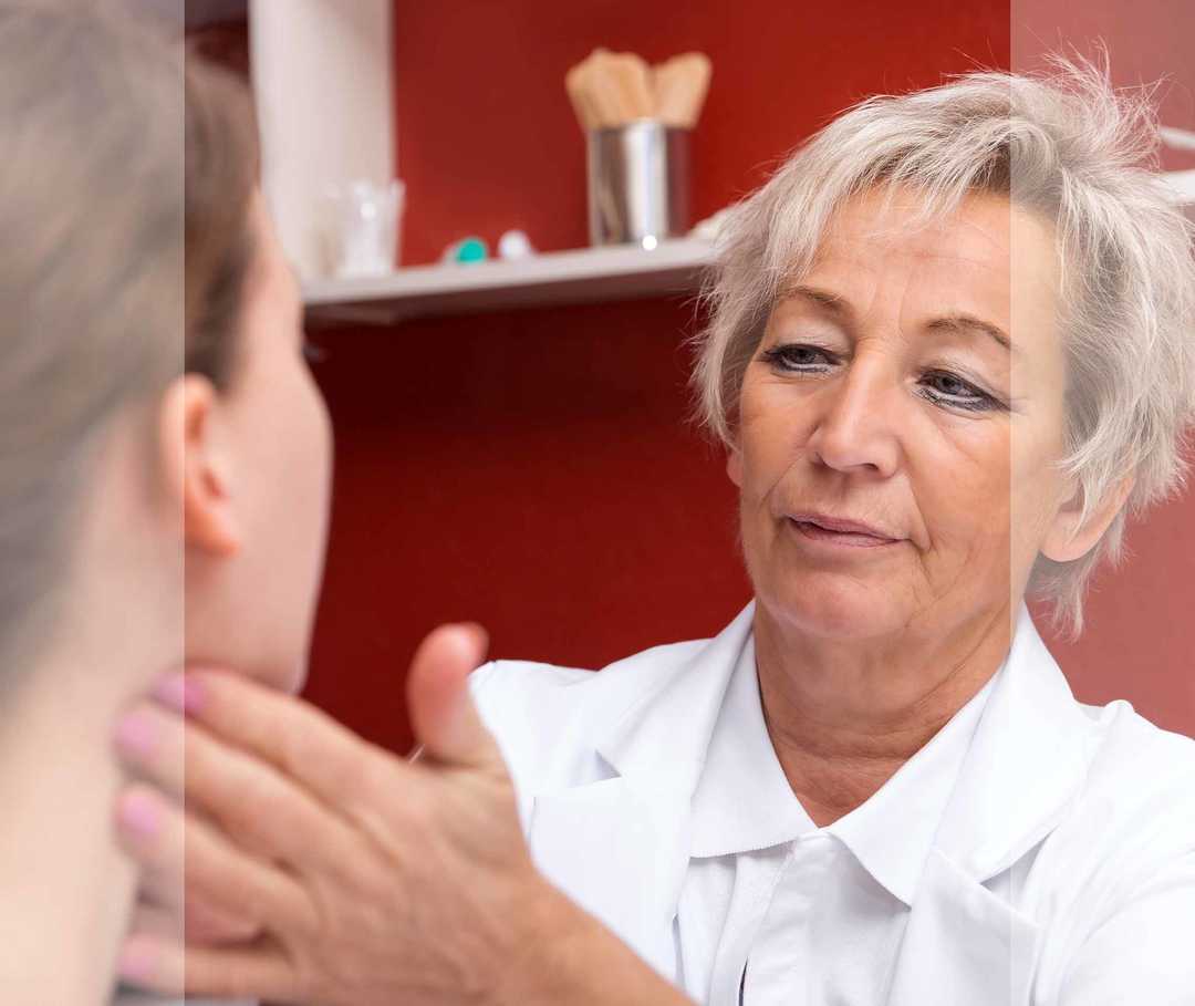 HNO-Ärztin untersucht den Hals einer Patientin.
