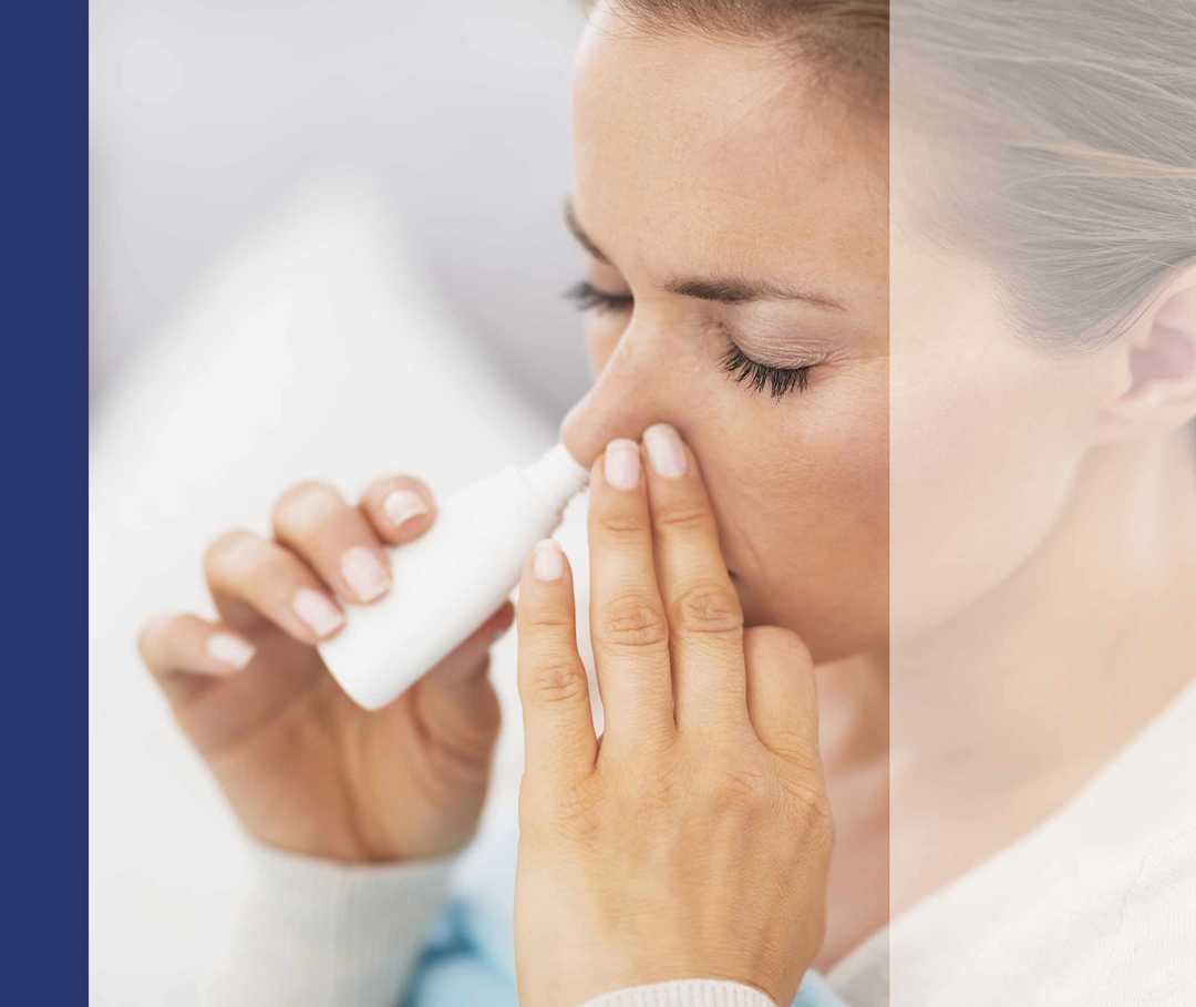 Nasenpolypen Therapie Medikamente 03 Eine Frau sprayt sich kortisonhaltiges Spray in ein Nasenloch.