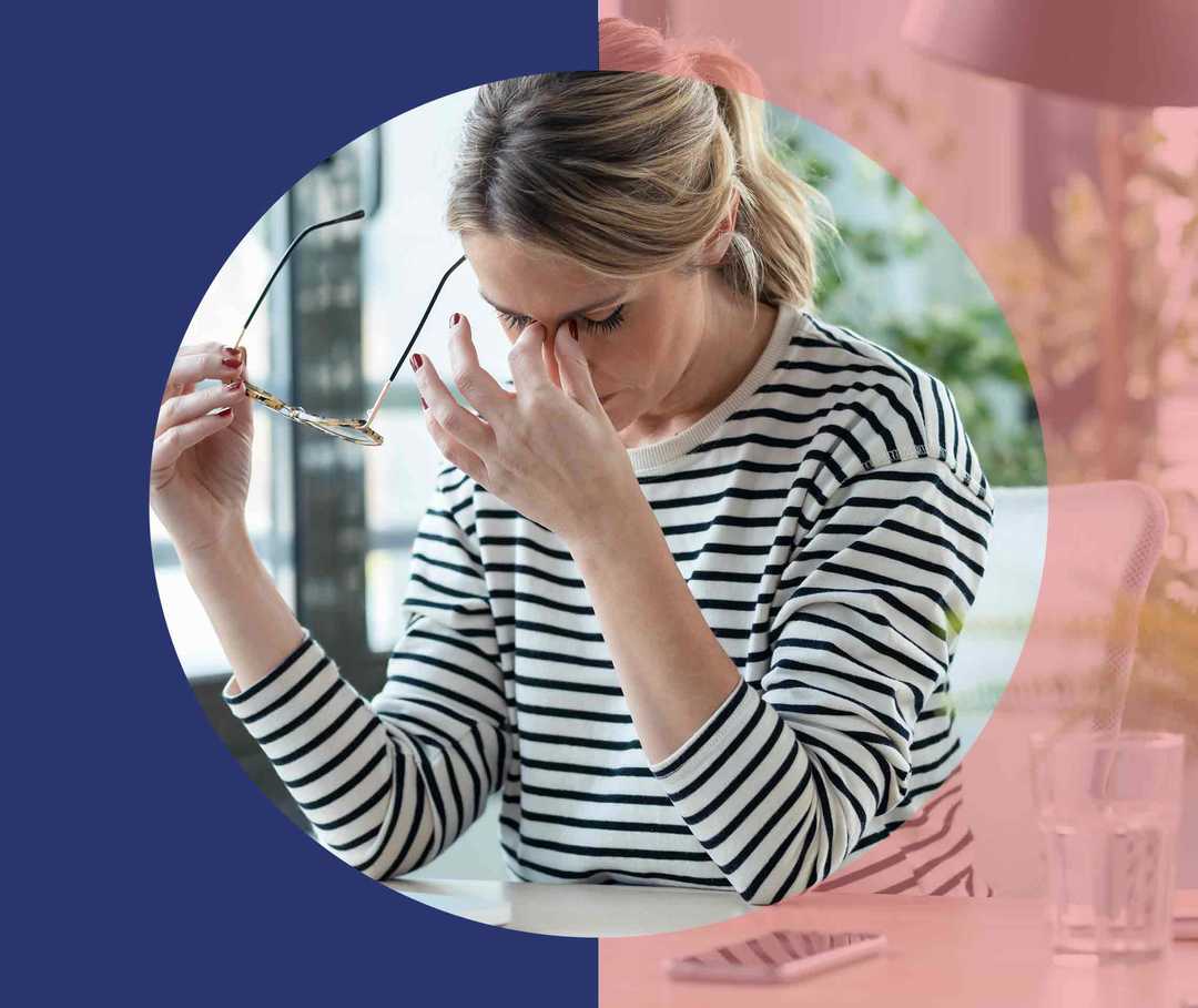 Nasenpolypen Ursachen Artikelbild 02 Frau sitzt am Arbeitsplatz, hält ihre Brille in der einen Hand und reibt sich den Nasenrücken mit der anderen