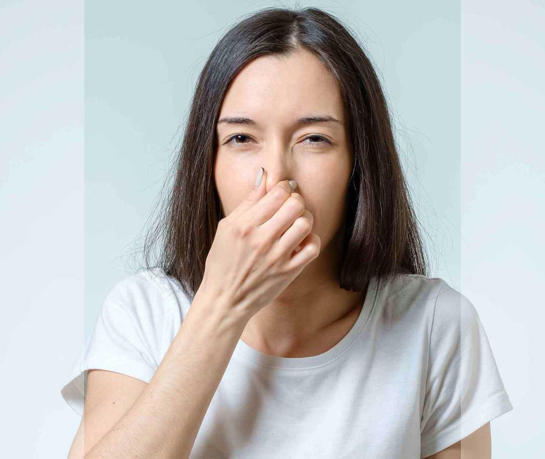 Eine Frau hält sich die Nase zu