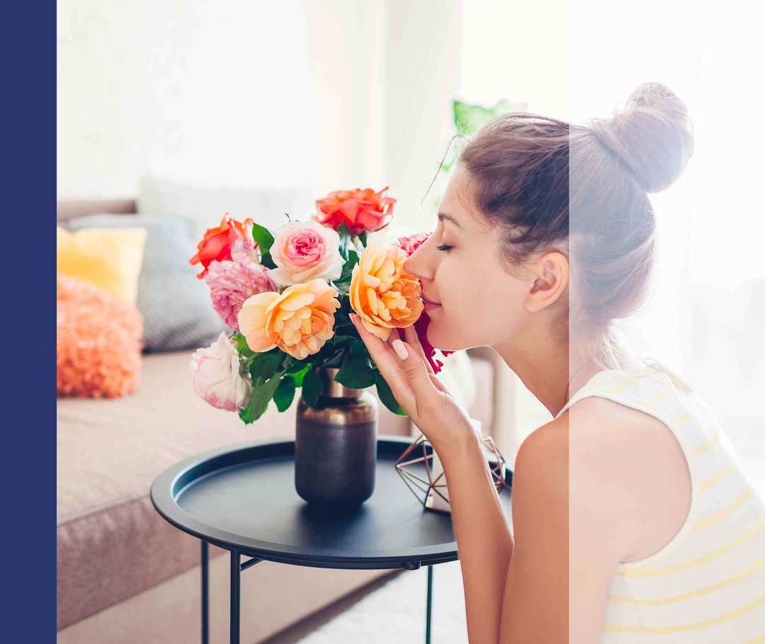 Eine Frau riecht an einem Blumenstrauß