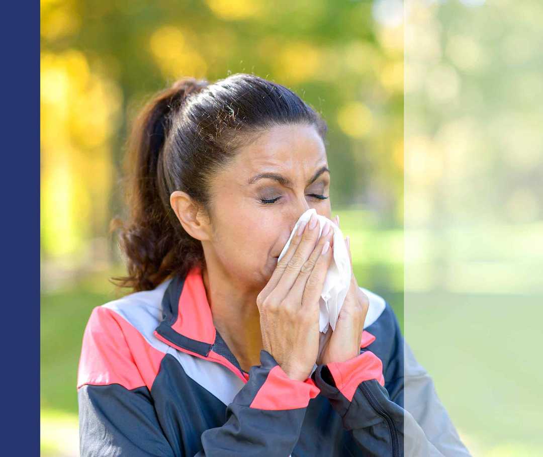 Nasenpolypen-info.de: Komplikationen Frau mit dunklen Haaren putzt sich die Nase.