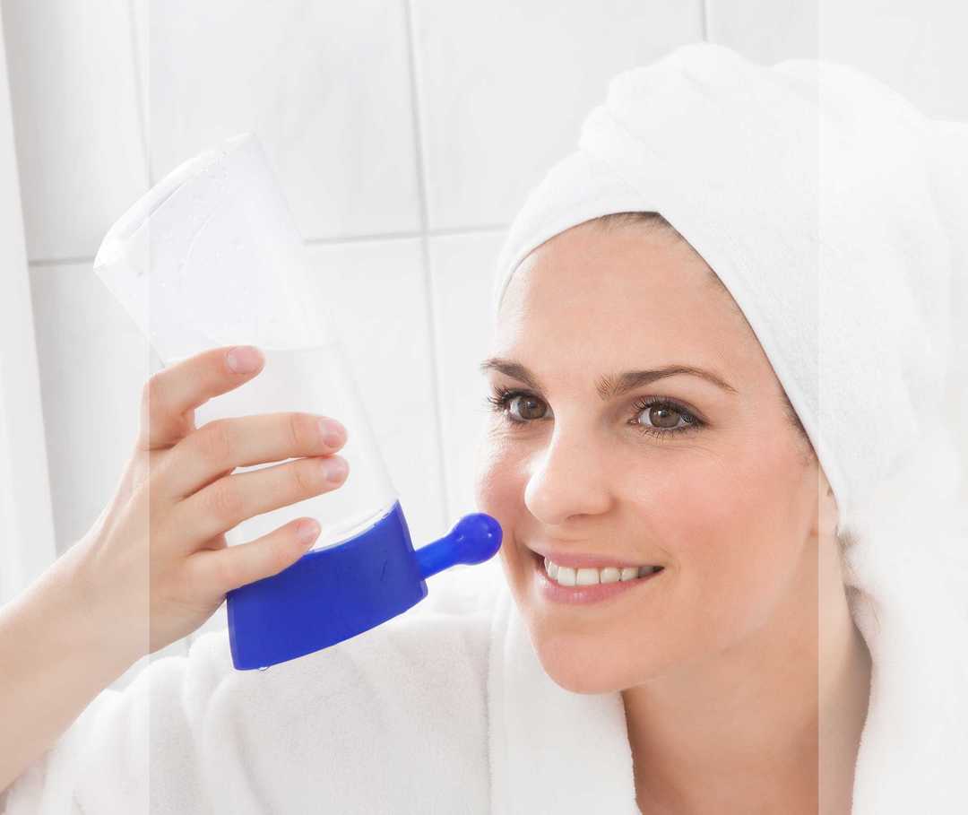 Eine Frau benutzt eine blaue Nasendusche