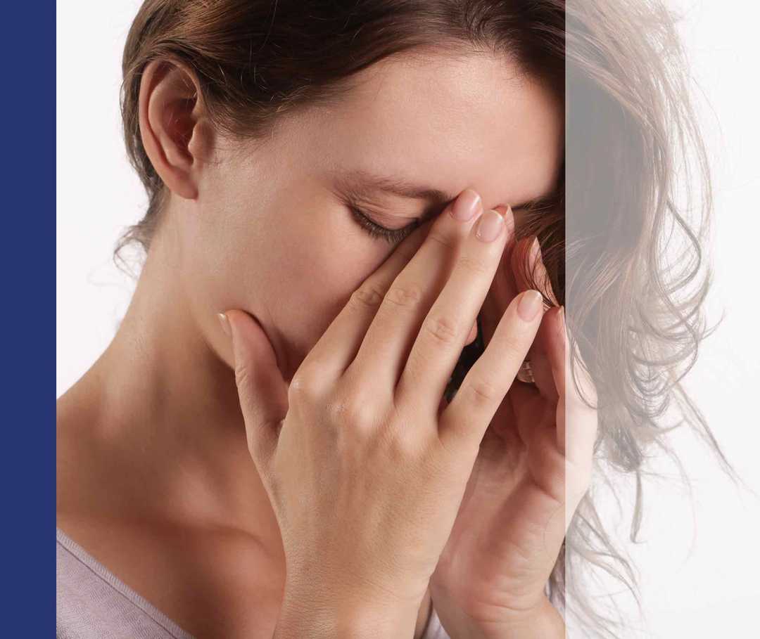 Frau hält sich die Hände ins Gesicht.